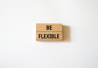 Be Flexible symbol. Wooden blocks with words Be Flexible. Businessman hand. Beautiful white background. Business and Be Flexible concept. Copy space.