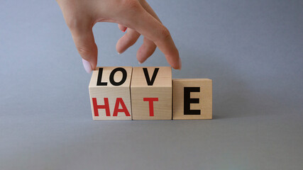 Love vs Hate symbol. Businessman Hand turns cubes and changes word Hate to Love. Beautiful grey background. Valentines day and Love vs Hate concept. Copy space