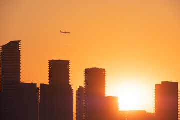 Plane over city skyline Toronto Canada during sunset