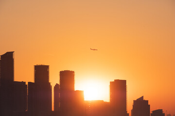 Plane over city skyline Toronto Canada during sunset