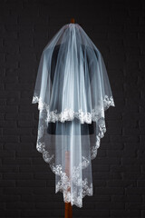 Wedding Veil. Studio photography against a dark, brick wall.