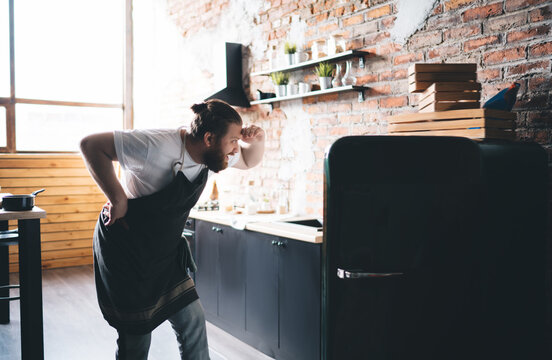 Man Staring Into Open Fridge