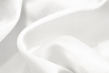 The texture of a fabric made of silk or calico with waves and rumples. Textile. Background of white material