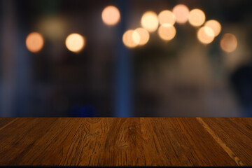 Empty wooden table in front of abstract blurred Cafe, restaurant at night. For montage product...