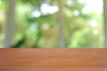 Empty wooden table in front of abstract blurred green of garden and nature light background. For...