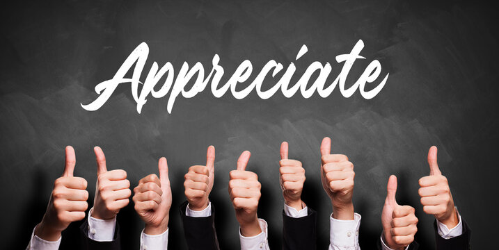 many business hands with thumbs up gesture in front of a blackboard with the word APPRECIATE