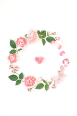 Engagement ring on the bottom of heart-shaped candy in the centre of floral wreath. Love, Valentine's Day, wedding concept.