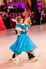 Attractive young couple of children dancing ballroom dance. Girl and boy dancer international dancing.