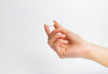 Hand holding a tablet on a white background, supplementation and health, physical and mental health...