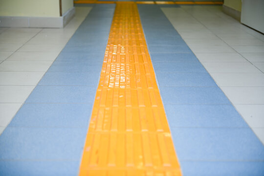 Perspective yellow tactile strip for cane or foot of blind person