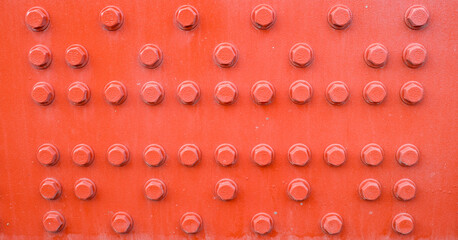 Red metal background with screws.