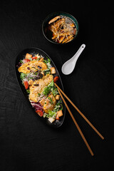 Caesar salad with baked chicken and miso soup on a black  background