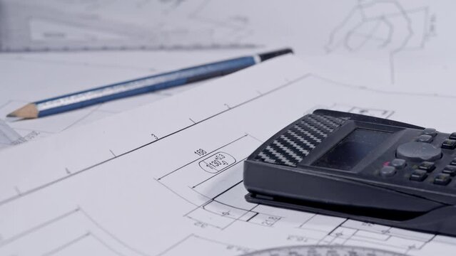 Footage macro of equipment and tools for drafting and estimating on architectural and structural drawings blueprints of construction projects. 