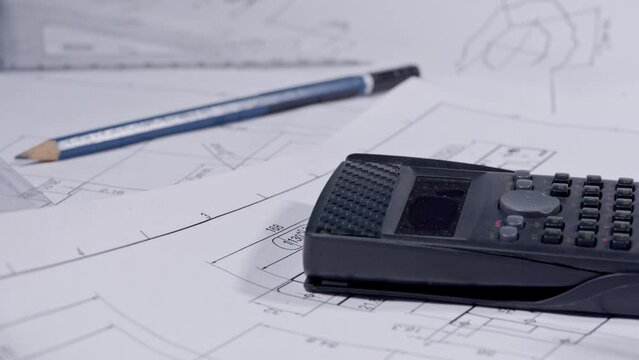 Footage macro of equipment and tools for drafting and estimating on architectural and structural drawings blueprints of construction projects. 