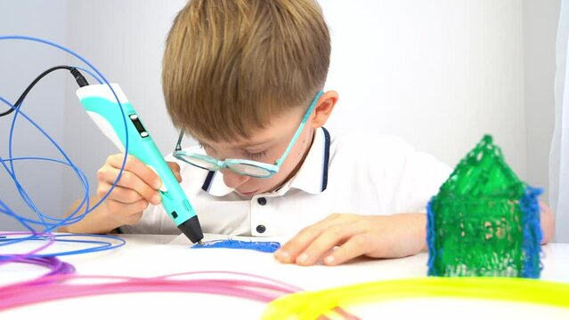 a boy draws with a 3d pen, additional classes and the concept of modern education for children