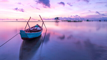 Portrait of a rowboat leaning on the edge of the pier at sunset in Maluku, Indonesia