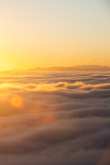 Fototapeta na wymiar Above the clouds at sunset with sun flares