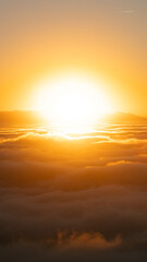 Above the clouds at sundown with a big brilliant sun in the center