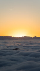 Fototapeta na wymiar Sea of clouds at sundown with mountains in the background