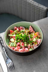 Fresh vegetable salad of tomatoes and cucumbers with sour cream in a plate.