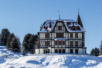 Riedalp, Switzerland - January 08. 2021: The famous Villa Cassel in winter. It was built in 1902 in Victorian architecture style and Sir Winston Churchill stayed here four times. - obrazy, fototapety, plakaty