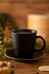 A transparent brown cup filled with citrus vitamin tea, a plate with citrus fruits in the form of tangerines