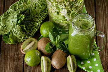 From above shot of green smoothie with fruit and vegetables on wood rustic table. selective focus