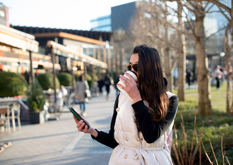 Happy woman drinking coffee reading online morning news on smartphone