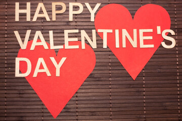 Valentine's Day sign with two red hearts on a brown blind. text: Happy Valentine's Day.