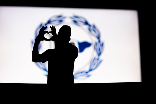 Young man making heart shape with his hands front of Arminia logo, love for football club idea, fan silhouette