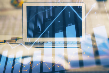 Financial chart drawing and table with computer on background. Multi exposure. Concept of international markets.