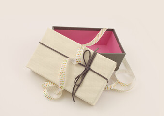 Craft empty gift box with ribbon  on light beige background. Copy space minimalism style template background.