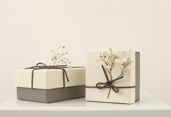 Craft gift boxes with flower on light beige background. Copy space minimalism style template...