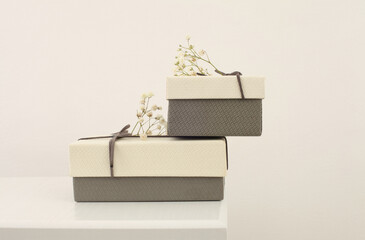 Craft gift boxes with flower on light beige background. Copy space minimalism style template...