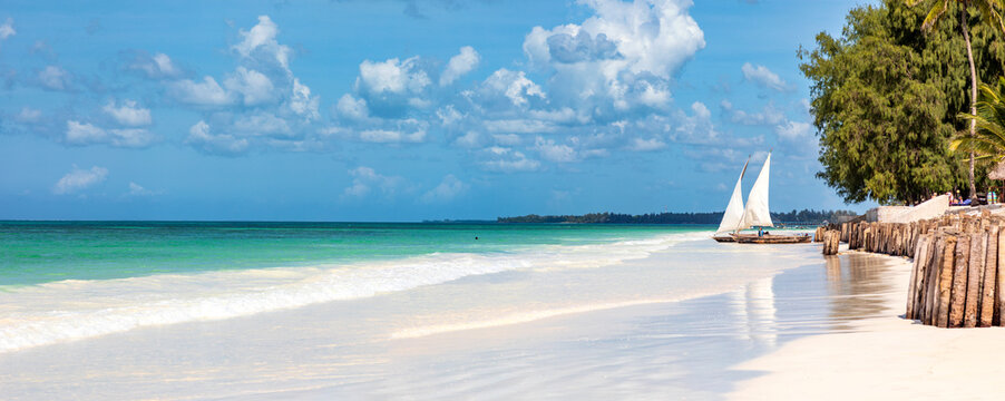 Segelboote an einem Strand. Im Hintergrund ein blauer Himmel mit Wolken,Panorama.