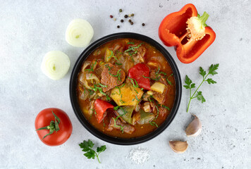 Georgian or Armenian meat khashlama with ingredients for cooking on a gray background. Top view.