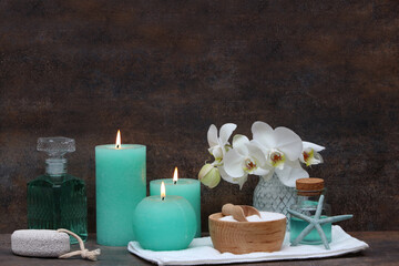 Spa Komposition mit Kerzen ,Orchideenblüte und Pflegeprodukten.	