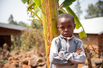 African child in the village with folded arms and angry face.
