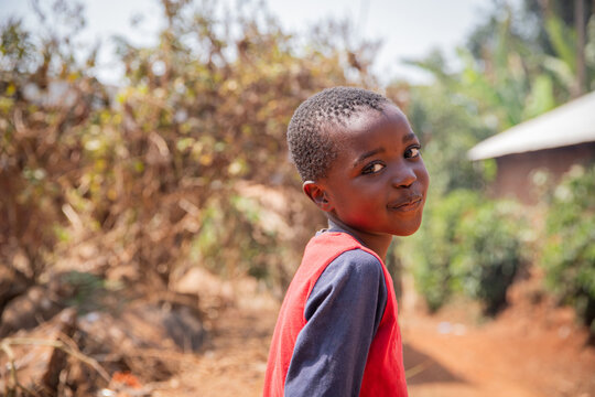 Portrait of a smiling African child in the village, photo with copy space.