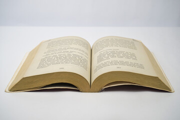Yogyakarta, Indonesia - January 06, 2023: Open old book on white background. Photographed using focus focus technique.