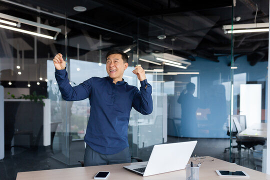 Happy young man businessman freelancer dancing in the office. Celebrates victory, successful deal, financial success, work break, rest.