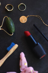 Various beauty products, accessories and jewelry on dark background. Selective focus.