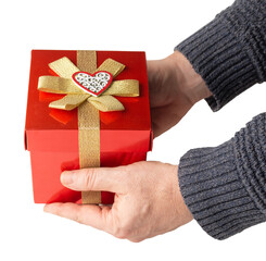 Hands of a man holding a red gift box with gold ribbon. Valentine's day concept