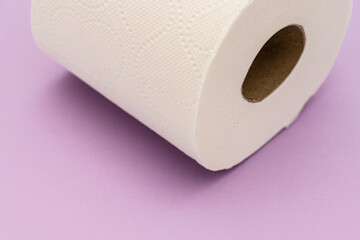 Roll of toilet paper on purple table.