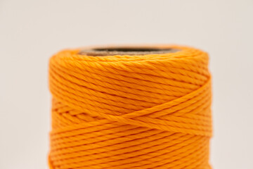 A roll of synthetic orange thread.