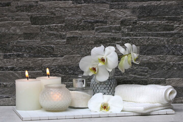 Spa-Komposition mit Orchidee weißem Handtuch und Duftkerzen. 