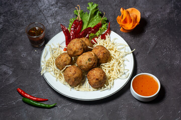 Fried Chicken Ball or kofta kabab eith tomato sauce served in dish isolated on grey background top view of indian and bangladesh food
