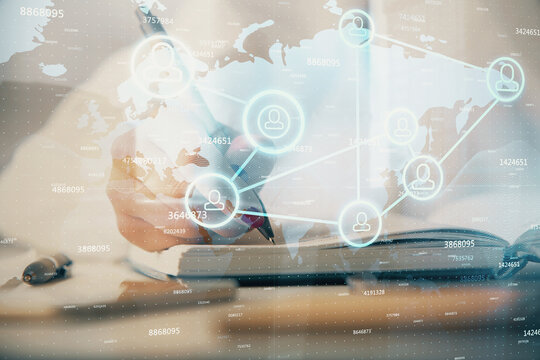 Social network theme hologram over hands taking notes background. Concept of global international people connect. Double exposure