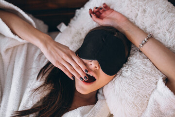 Woman in bed wearing sleeping mask