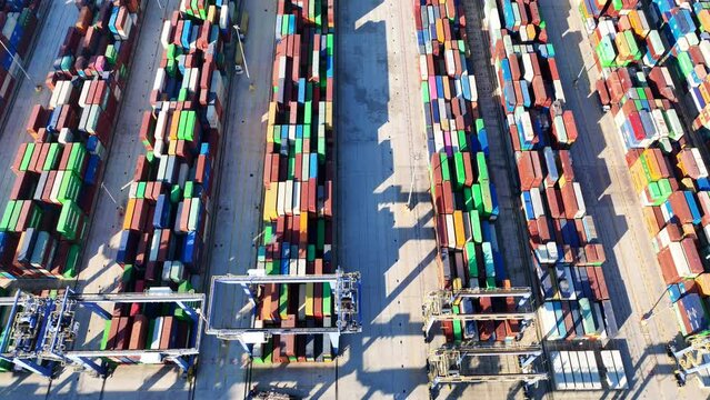 Aerial drone top down pan video of colourful containers stacked in Mediterranean container terminal